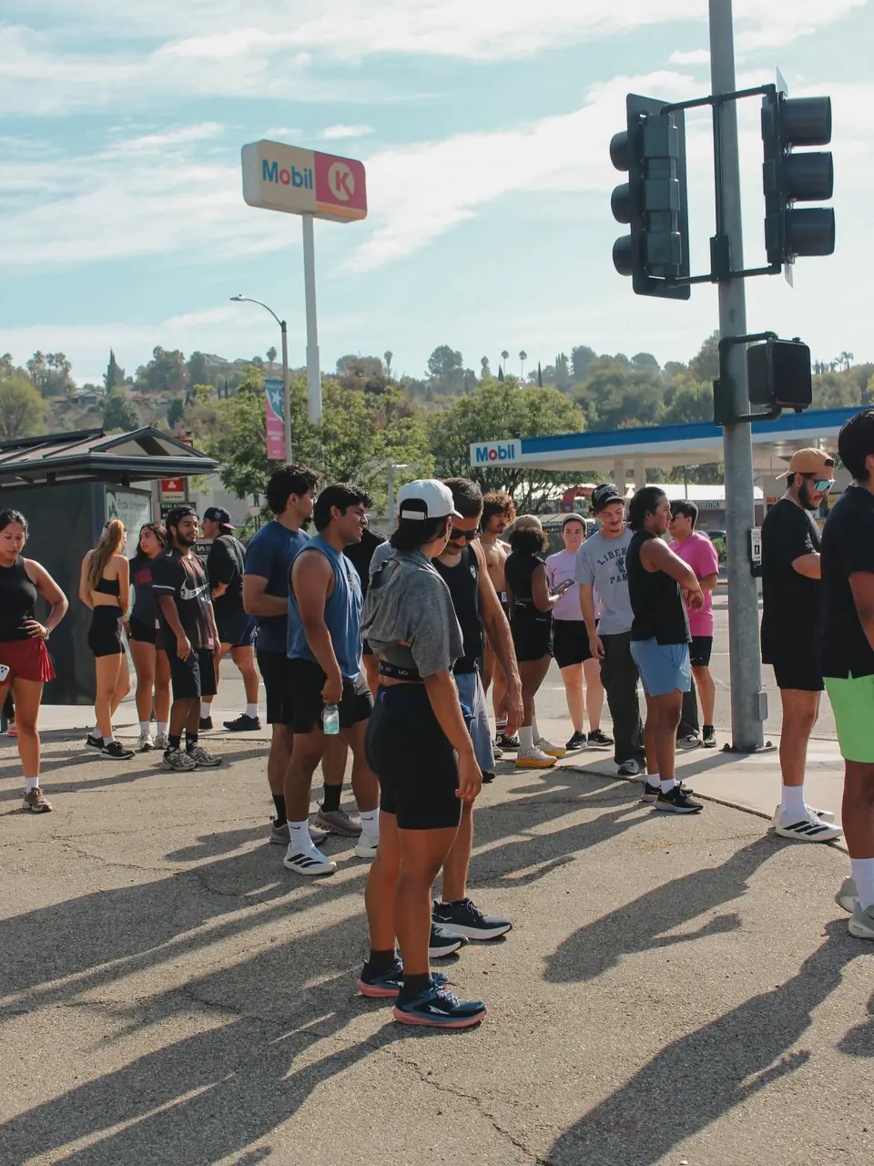 Crowd of runners waiting at a street corner for the crosswalk signal