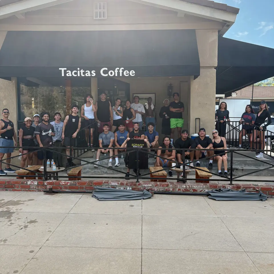 Full crew posing with a SÜPAFIT Run Club sign at Tacitas Coffee in Diamond Bar