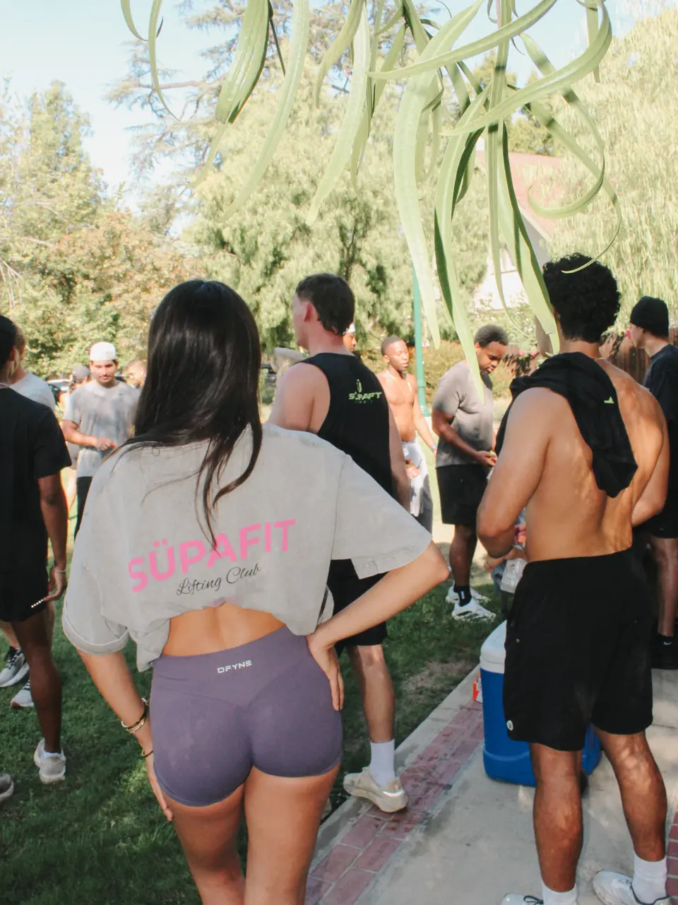 Runner in a SÜPAFIT tee hanging out with the crew on the grass