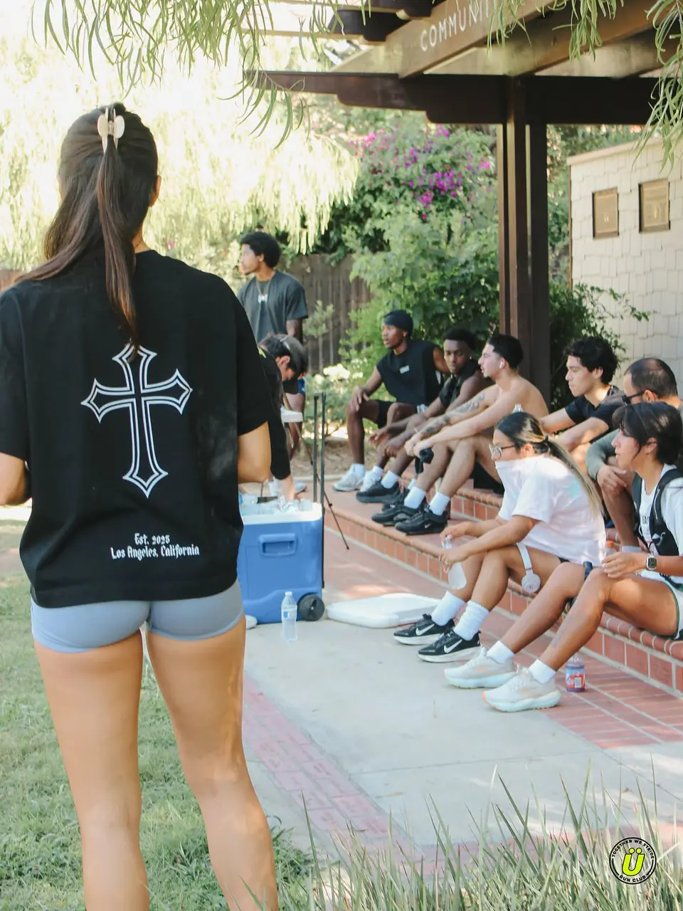 Runners sitting on a brick ledge in the shade, cooling down after the miles