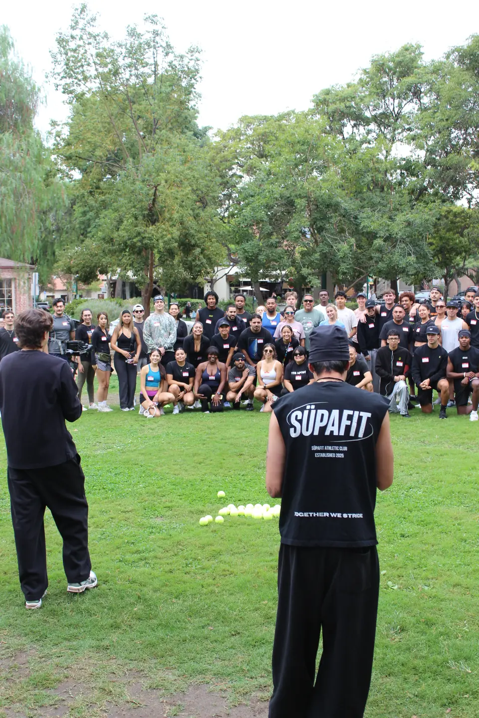 Full crowd posing on the grass for the group shot at Shelton Park in Claremont